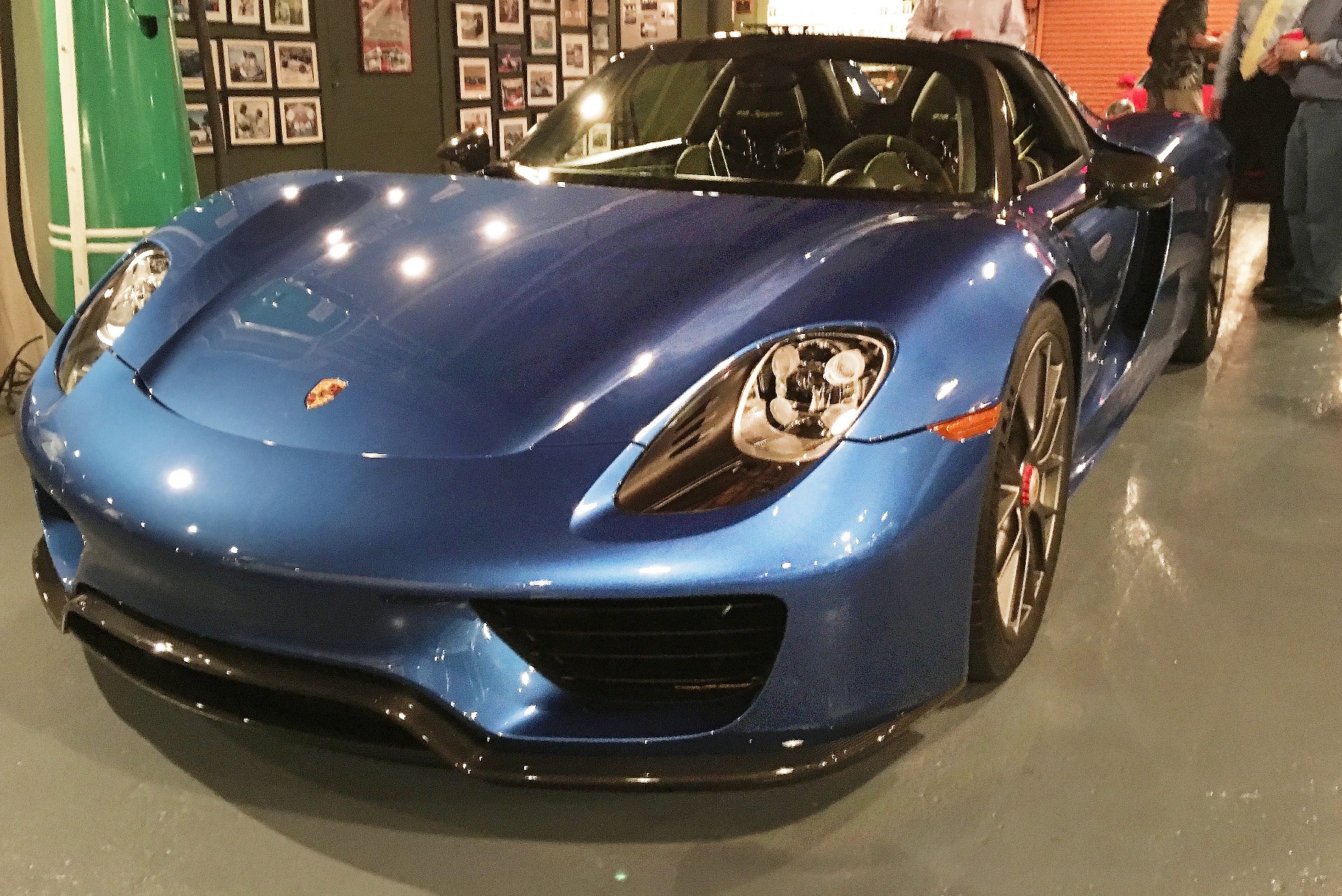 A blue Porsche 918 Spyder in the hall beside the photograph wall