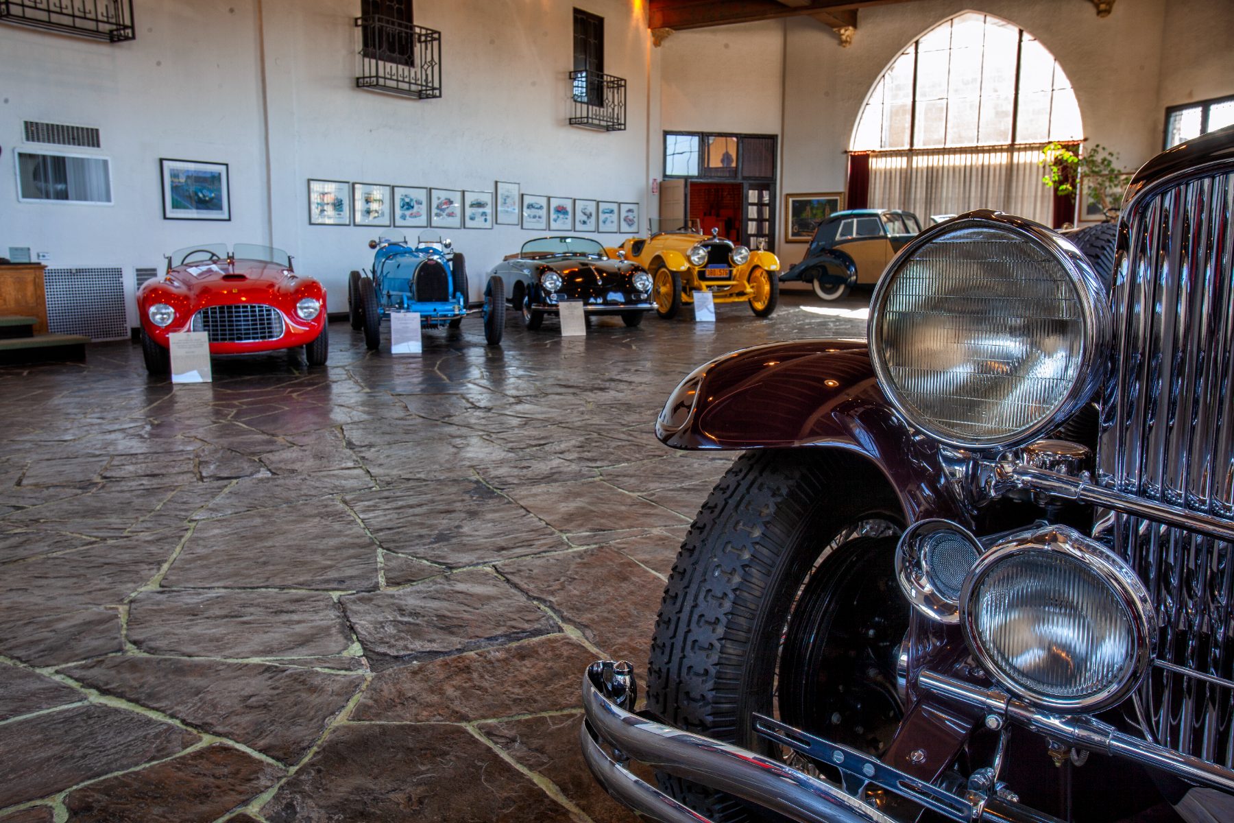 The entry hall seen from the door, cars beneath cathedral windows