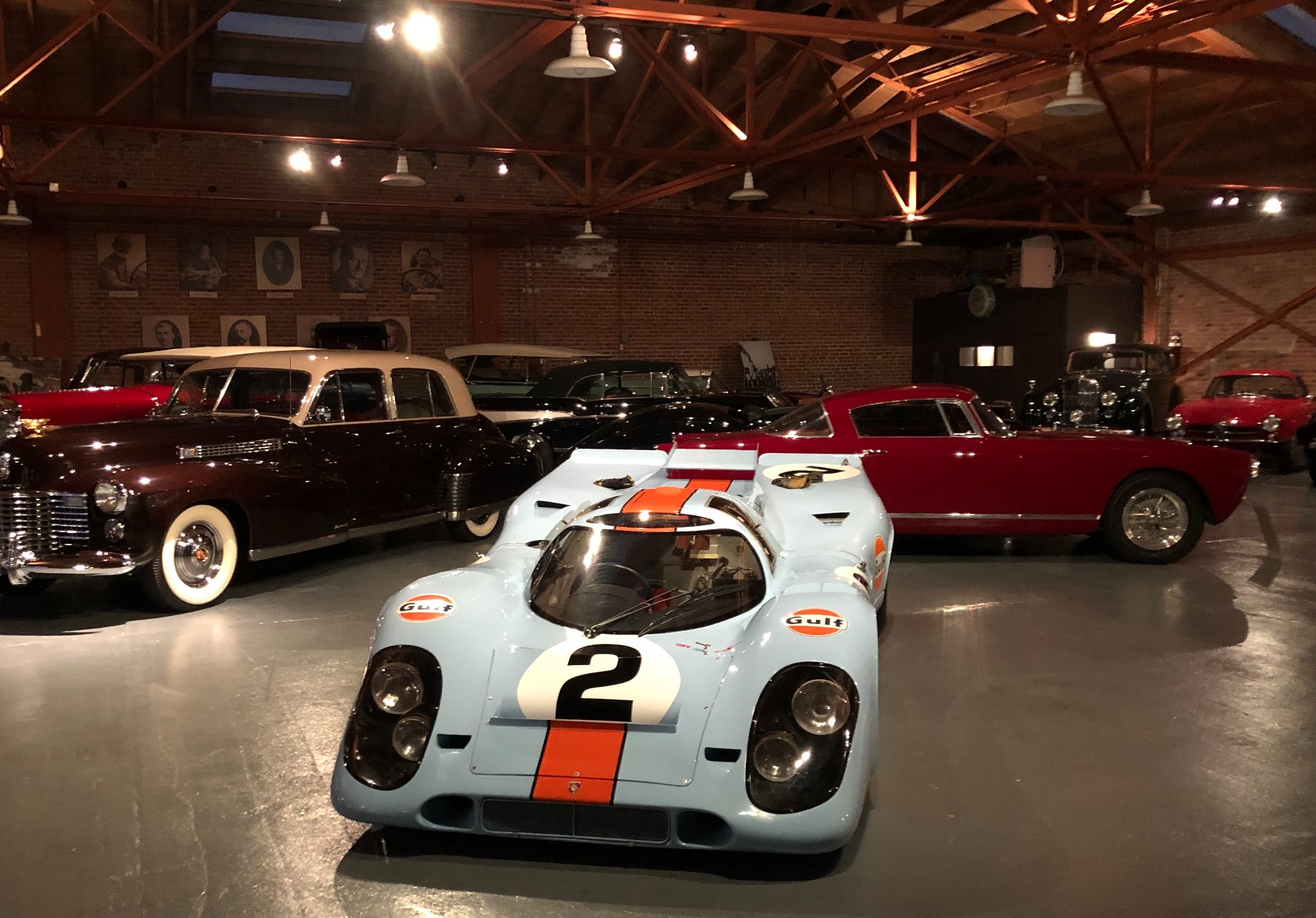 A Gulf-liveried Porsche 917 among the collection beneath the timber trusses